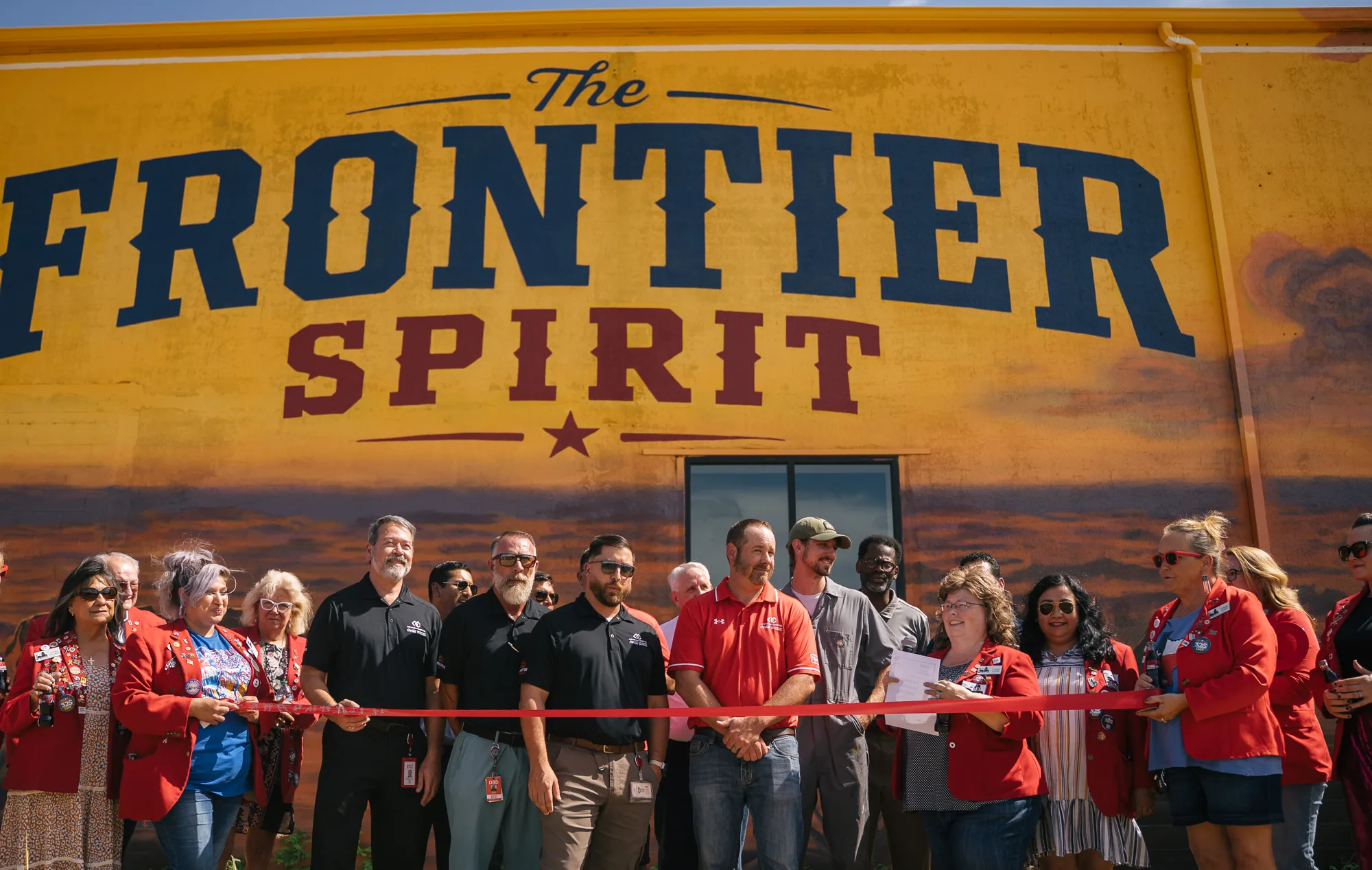 Ribbon cutting in front of the finished Coca-Cola mural in Abilene, Texas