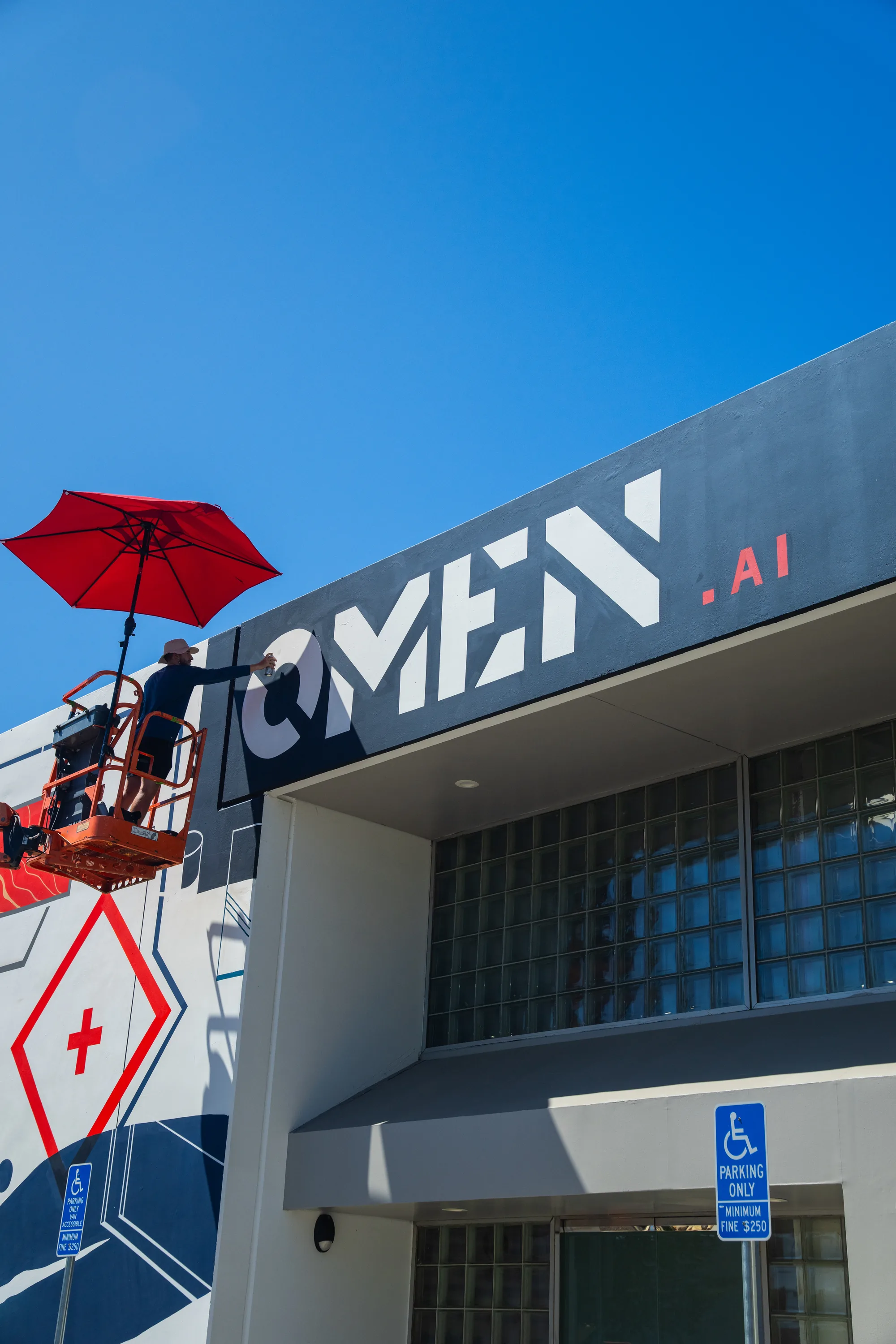 Omen AI building signage alongside the hand painted mural facade